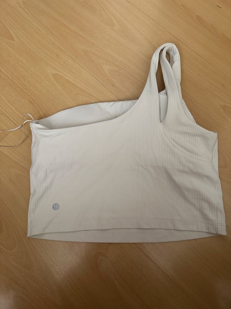 Lululemon Ribbed One Shoulder Crop Align White Top (Category: Activewear) located in Cavite. Submitted by _mariposa.mnl (Listing ID 1465833918, Image 2). Description: - Brand: Lululemon (dot 10) - Style: Asymmetric one-shoulder with double strap accent and straight hem - Support: Built-in shelf bra included - Details: Iconic silver logo heat transfer near bottom left hem - Material: Premium ribbed textured fabric - Versatility: Ideal for workouts