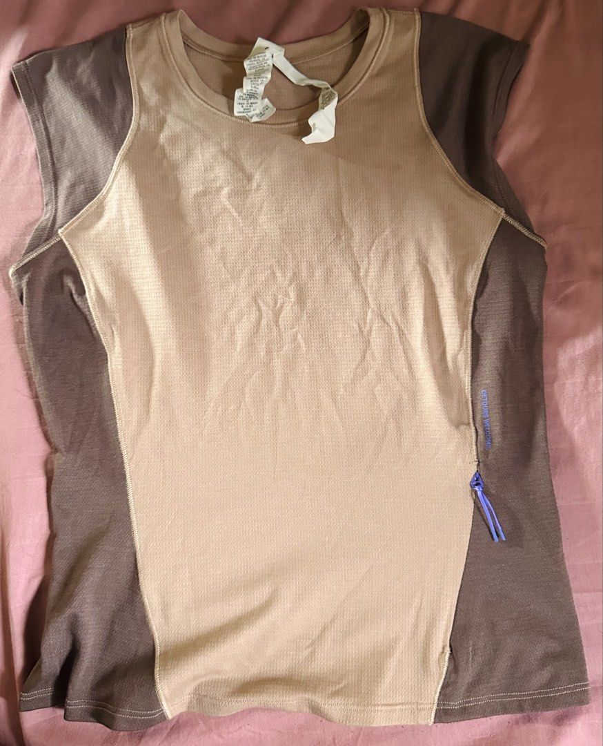 Lululemon Tank Top (Category: Activewear) located in Butuan. Submitted by slownsteady_ (Listing ID 1465814832, Image 1). Description: - Brand: Lululemon - Size: 4 - Color: Brown and tan colorblock design - Details: 'Detours Welcome' text near the side zipper pocket, contrast shoulder and side panels - Logo: Minimalist Lululemon square logo printed on the back - Material: Soft, high-quality athletic textured fabric - Ideal for: Gym workouts or cas