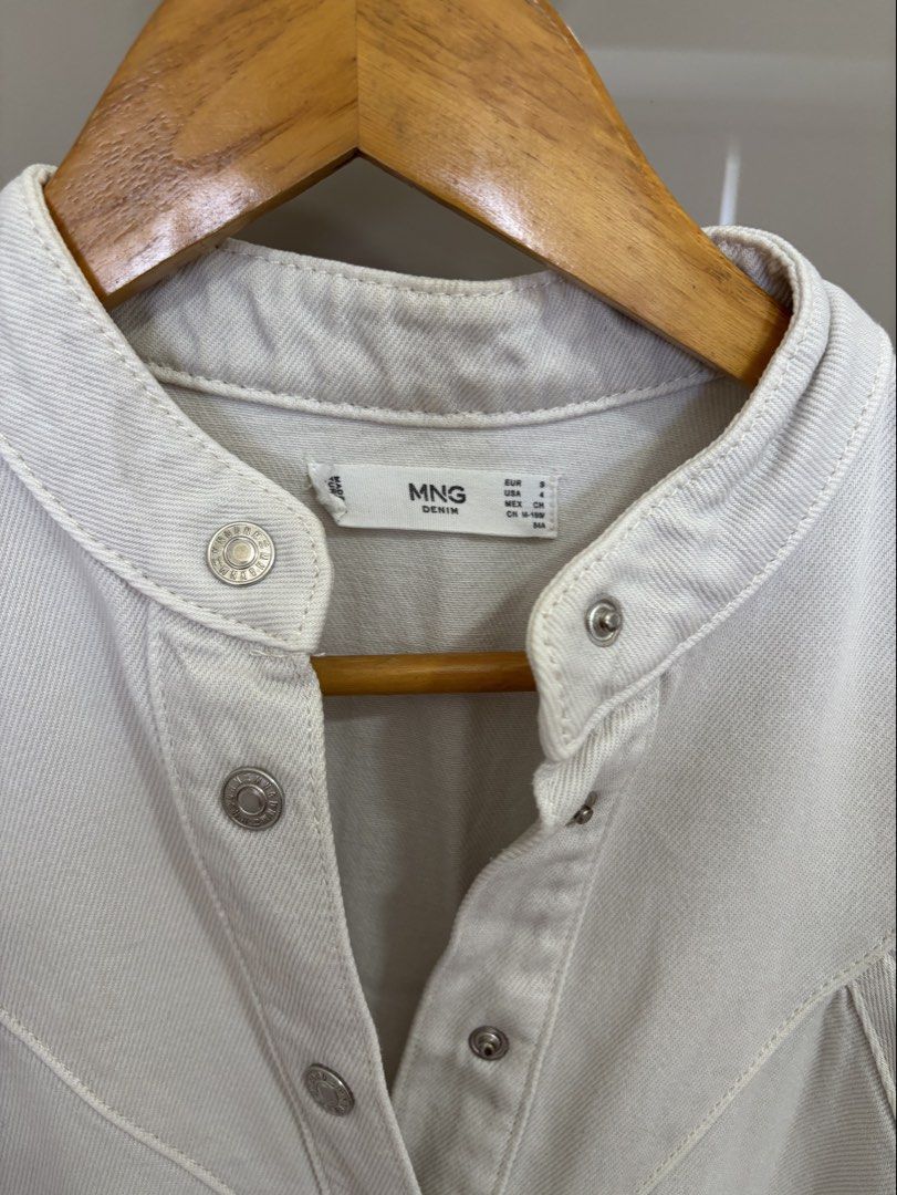 Mango Denim White Dress (Category: Dresses) located in Pasay City. Submitted by mommapauie (Listing ID 1465902662, Image 3). Description: - Brand: MNG - Item: White denim dress - Size: Small - Closure: Snap button front down the chest - Sleeves: Short sleeves with gathered cuffs - Neckline: Stand-up collar - Details: Two front pockets on the skirt and a fitted waist with belt loops - Condition: Excellent/ No tag but never Used.