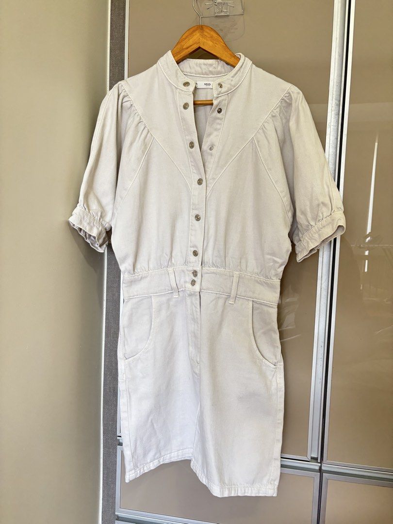 Mango Denim White Dress (Category: Dresses) located in Pasay City. Submitted by mommapauie (Listing ID 1465902662, Image 2). Description: - Brand: MNG - Item: White denim dress - Size: Small - Closure: Snap button front down the chest - Sleeves: Short sleeves with gathered cuffs - Neckline: Stand-up collar - Details: Two front pockets on the skirt and a fitted waist with belt loops - Condition: Excellent/ No tag but never Used.