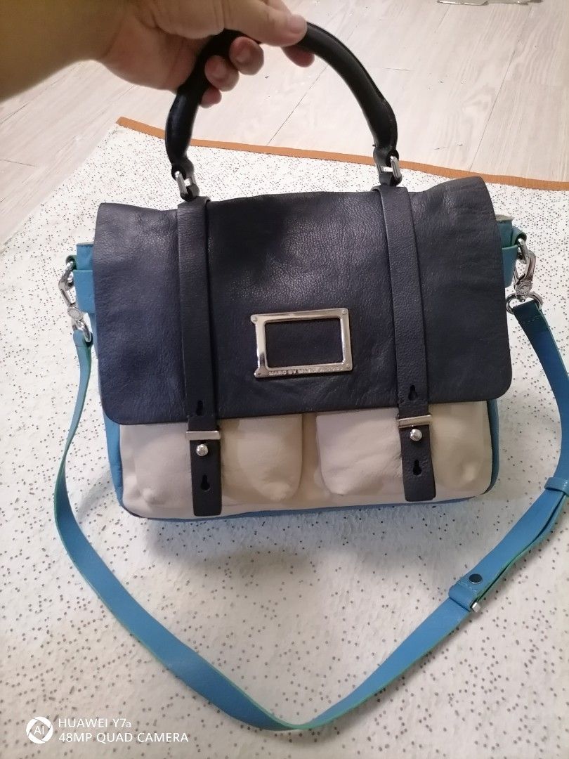 Marc by Marc Jacobs Leather Satchel (Category: Luxury Bags & Wallets) located in Naga. Submitted by mrwisethrifter (Listing ID 1465827028, Image 1). Description: - Brand: Marc by Marc Jacobs - Design: Colorblock in chic black, cream, and blue - Versatile Carry: Includes a top handle and an adjustable blue shoulder strap - Secure & Stylish: Front flap closure with dual vertical straps and silver-tone metal plaque hardware - Storage: Two convenient