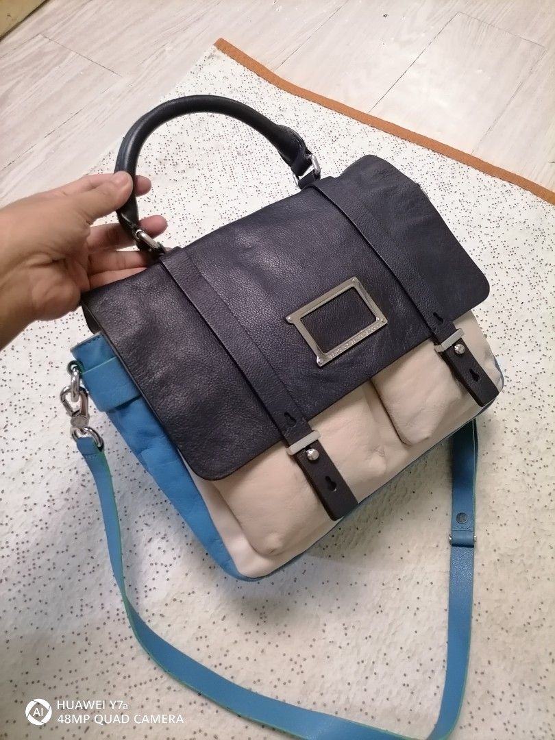 Marc by Marc Jacobs Leather Satchel (Category: Luxury Bags & Wallets) located in Naga. Submitted by mrwisethrifter (Listing ID 1465827028, Image 2). Description: - Brand: Marc by Marc Jacobs - Design: Colorblock in chic black, cream, and blue - Versatile Carry: Includes a top handle and an adjustable blue shoulder strap - Secure & Stylish: Front flap closure with dual vertical straps and silver-tone metal plaque hardware - Storage: Two convenient