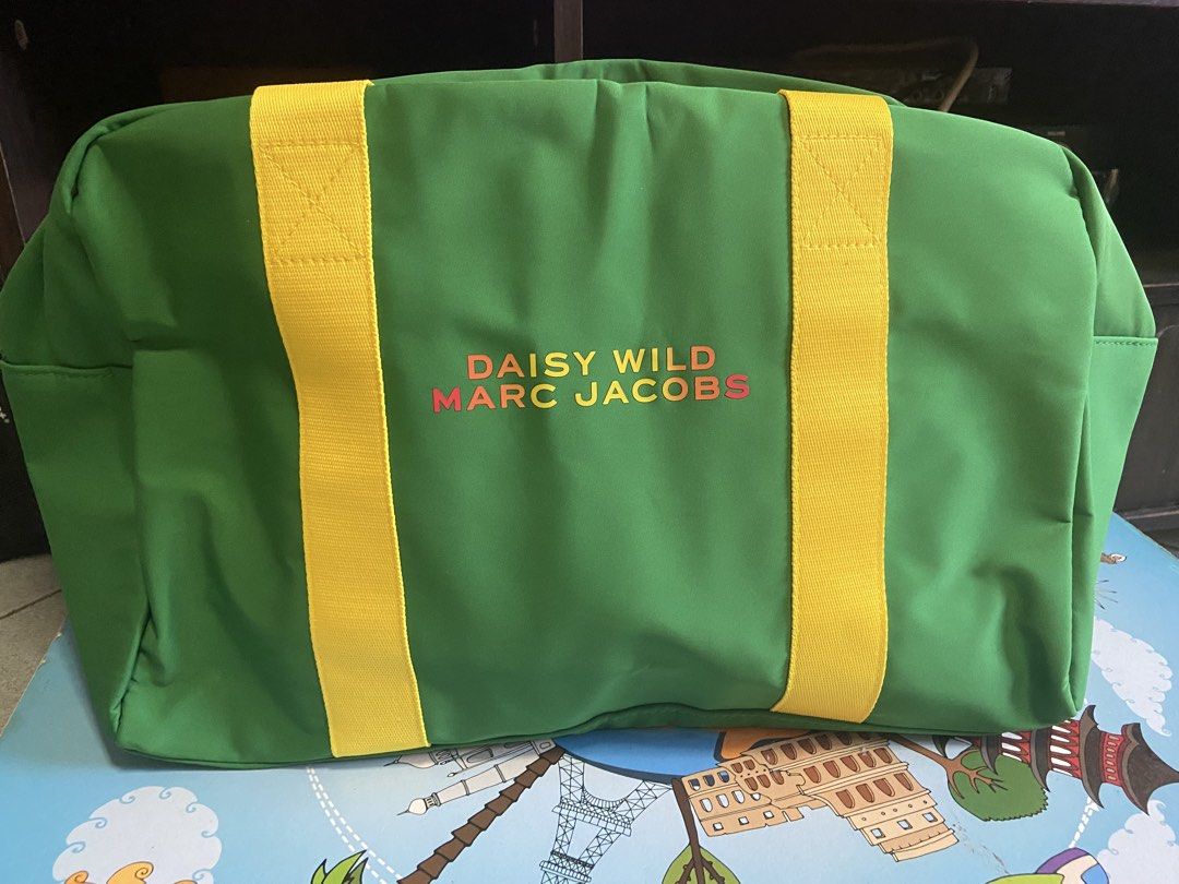 Marc Jacobs Daisy Wild Duffel Bag (Category: Luxury Bags & Wallets) located in Silang. Submitted by Apple_Mac07 (Listing ID 1465826216, Image 3). Description: Green canvas duffel bag with bright yellow handles. Front printed with Daisy Wild Marc Jacobs lettering in pink and orange. Pink zipper features a flower-shaped pull tag. Inside lined with vibrant orange and red fabric. Brand new with tag attached..