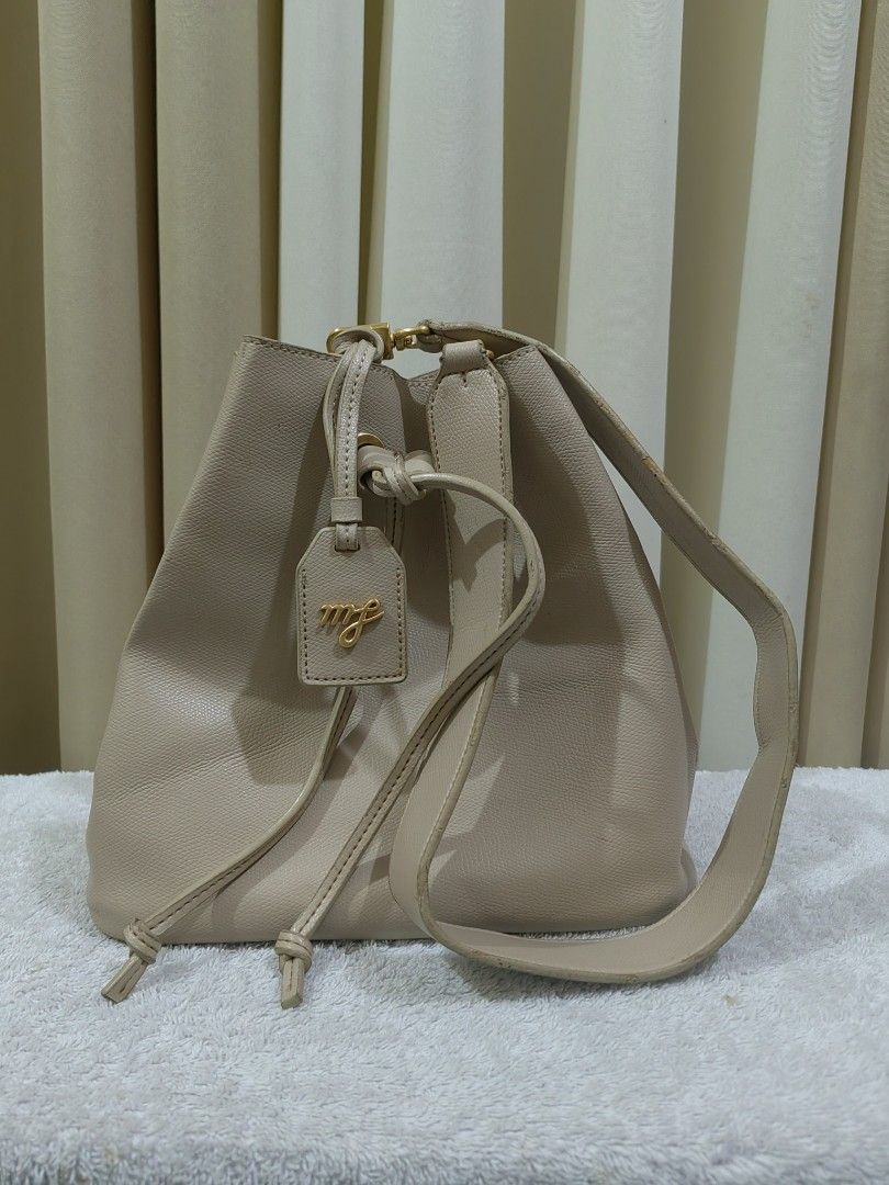 Marhen.J Beige Bucket Bag with Drawstring and Charm (Category: Shoulder Bags) located in Makati City. Submitted by prelovedtreatedwithlove (Listing ID 1465830547, Image 2). Description: - Brand: Marhen.J - Color: Versatile neutral beige - Material: Textured faux leather with elegant gold hardware - Closure: Secure top drawstring - Interior: Open compartment with a convenient side pocket - Includes: Matching brand charm on the strap - Condition: M