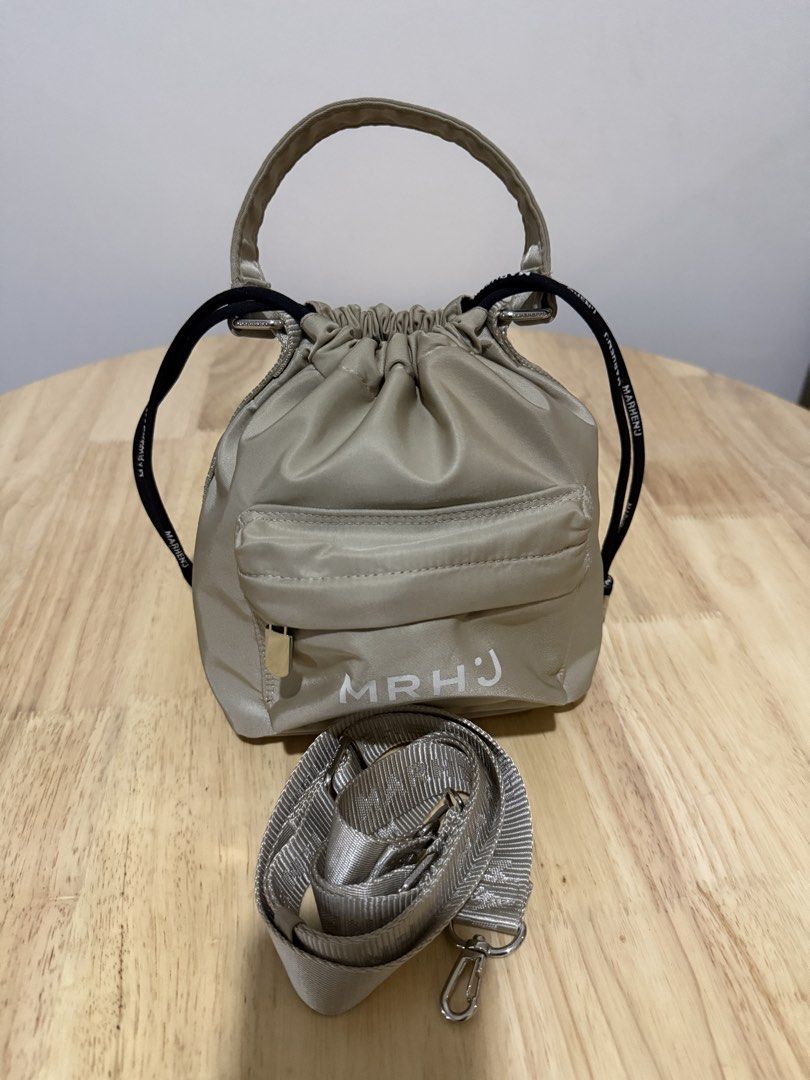 Marhen.J beige nylon drawstring bucket bag with strap (Category: Shoulder Bags) located in Mandaluyong City. Submitted by decmnl (Listing ID 1465858983, Image 2). Description: - Brand: Marhen.J - Material: Lightweight beige nylon - Closure: Drawstring top with front zipped pocket (featuring white MRHJ lettering) - Details: Dual black side pull cords with brand text and silver hardware - Strap: Includes matching adjustable shoulder strap - Conditi