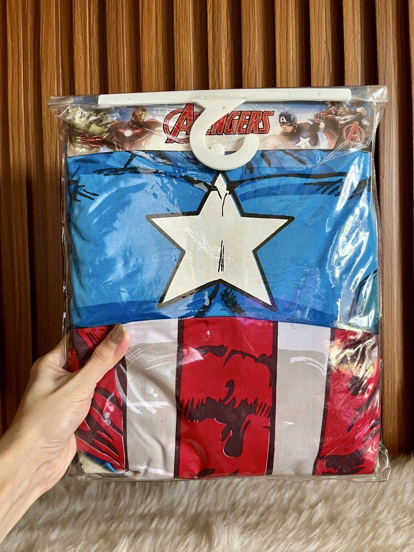 Marvel Avengers Captain America Costume (Category: Babies & Kids Fashion) located in Navotas City. Submitted by mommybabyc (Listing ID 1465876475, Image 1). Description: - Official Marvel Avengers Captain America costume - Brand new in original packaging with hanger intact - Includes iconic blue top with white star and striped lower section - Features official Avengers graphics on packaging back - Multiple size options available.
