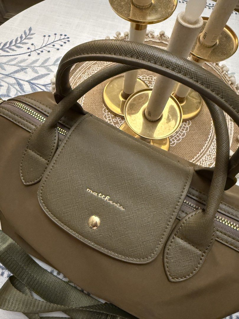 Matthews Olive Green Top Handle Bag with Strap (Category: Luxury Bags & Wallets) located in Quezon City. Submitted by cndcvrtc (Listing ID 1465945521, Image 2). Description: - Brand: Matthews - Color: Versatile olive green (neutral earth tone) - Material: Durable nylon with Saffiano textured flap - Hardware: Elegant gold-toned accents throughout - Closure: Gold-toned snap button flap and secure zip top opening - Straps: Dual top handles + matchin