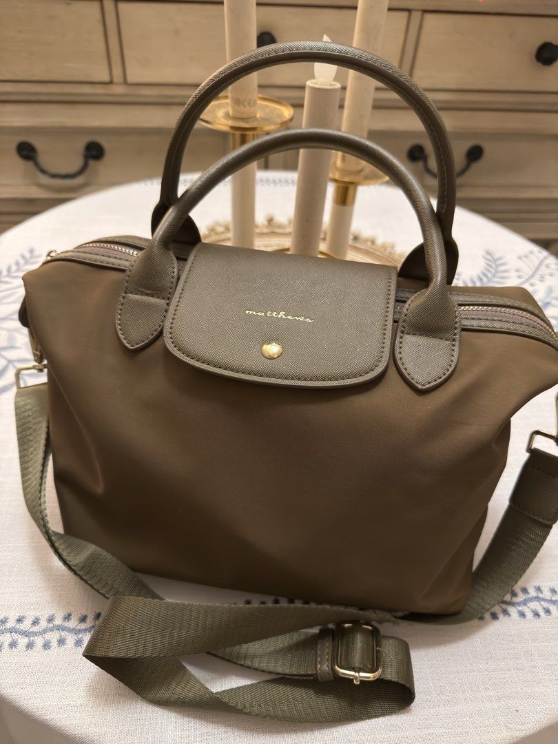 Matthews Olive Green Top Handle Bag with Strap (Category: Luxury Bags & Wallets) located in Quezon City. Submitted by cndcvrtc (Listing ID 1465945521, Image 1). Description: - Brand: Matthews - Color: Versatile olive green (neutral earth tone) - Material: Durable nylon with Saffiano textured flap - Hardware: Elegant gold-toned accents throughout - Closure: Gold-toned snap button flap and secure zip top opening - Straps: Dual top handles + matchin