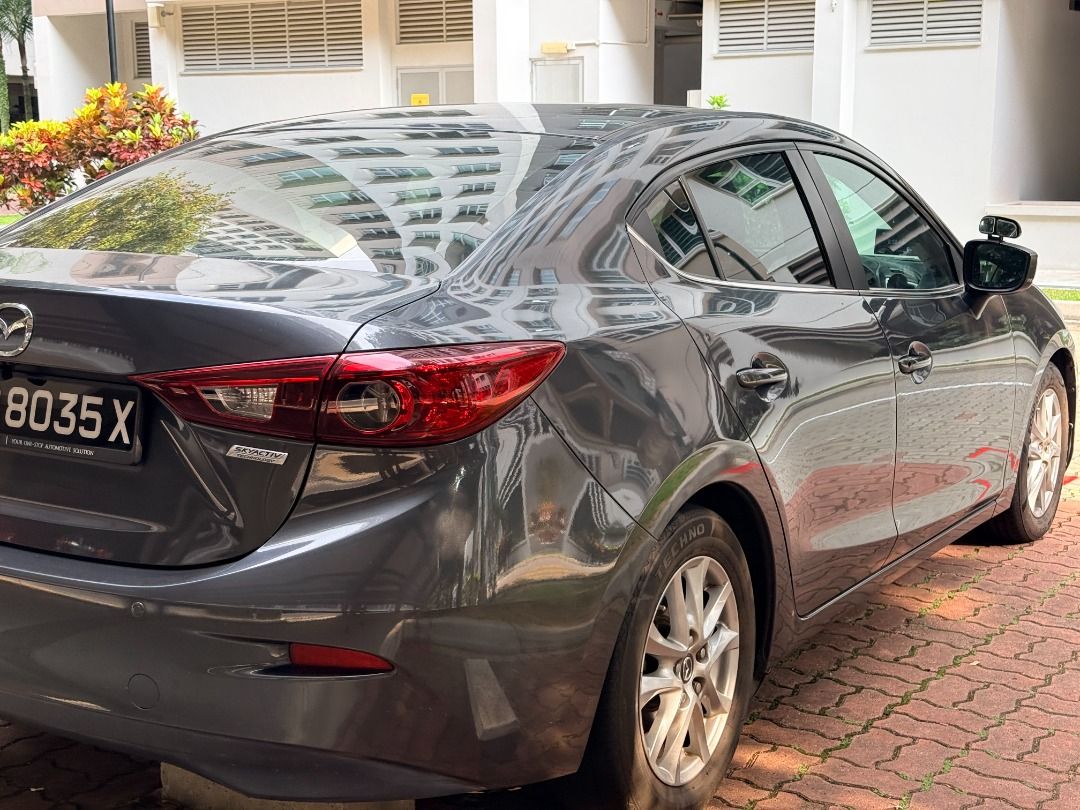 Mazda 3 Sedan 1.5 SP (A) (Category: Used Cars) located in Singapore. Submitted by dd520bb (Listing ID 1465869931, Image 3). Description: Direct owner selling my grey Mazda3 automatic. Highlights: • Upgraded touchscreen infotainment system with Apple CarPlay. • Mileage of 88,689 km at the time the photos were taken. • Black seats with red stitching. Photos show the exterior, front and rear seats, dashboard with the infotainment screen switched on,