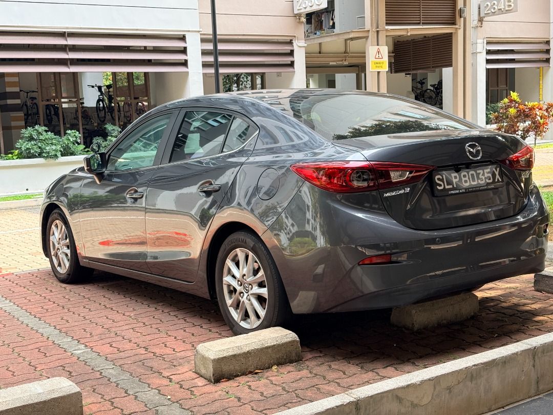 Mazda 3 Sedan 1.5 SP (A) (Category: Used Cars) located in Singapore. Submitted by dd520bb (Listing ID 1465869931, Image 2). Description: Direct owner selling my grey Mazda3 automatic. Highlights: • Upgraded touchscreen infotainment system with Apple CarPlay. • Mileage of 88,689 km at the time the photos were taken. • Black seats with red stitching. Photos show the exterior, front and rear seats, dashboard with the infotainment screen switched on,