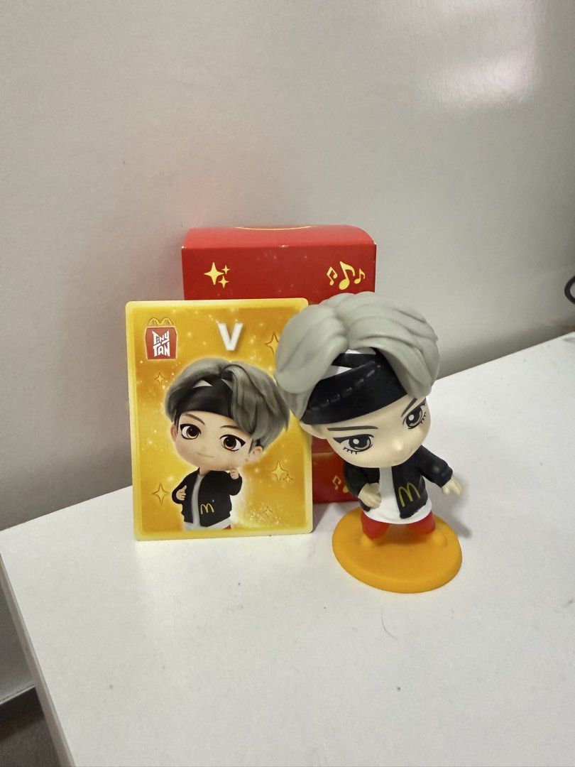 McDonald's TinyTAN V Figure with Photocard and Box (Category: Designer & Blind Box Toys) located in Quezon City. Submitted by hooniecart0 (Listing ID 1465901607, Image 1). Description: - Official McDonald's TinyTAN figure featuring V (BTS) - Includes matching yellow collectible photocard - Comes with original red blind box - Figure includes round orange base - Clean and well-kept, straight from the meal promo - Must-have for BTS and K-pop collect
