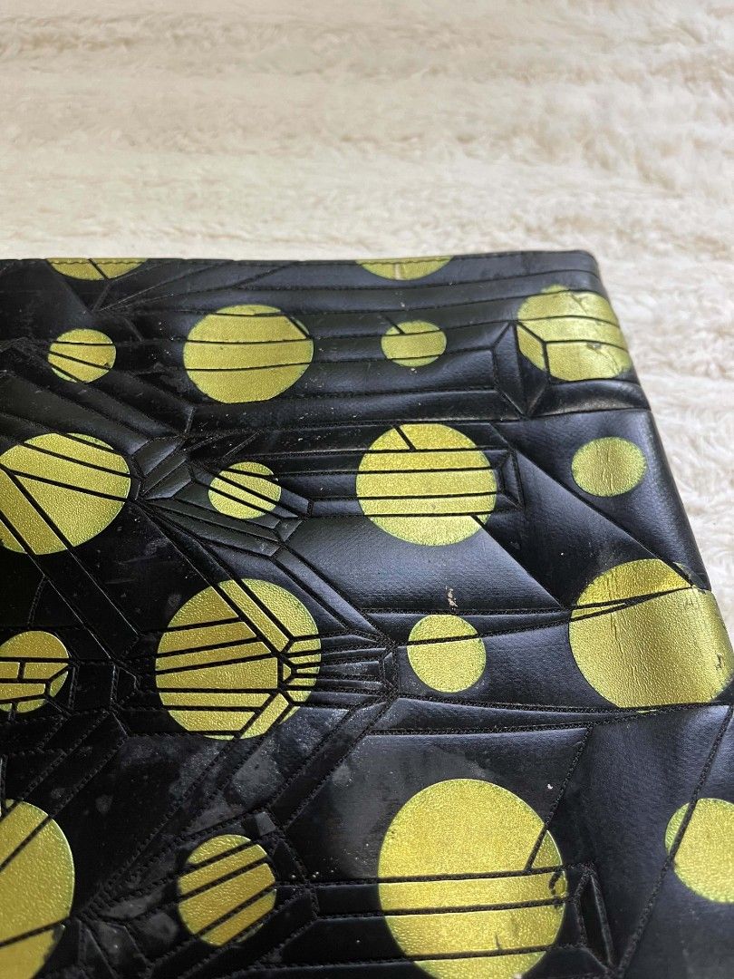 MCM Black and Gold Geometric Pattern Zip Clutch (Category: Clutches) located in Naawan. Submitted by twilly.apparel2 (Listing ID 1465825474, Image 3). Description: - issue may pressed mark and sign of use - authenticy NOT Guaranteed Eye-catching black clutch with bold gold polka dots and geometric linework - Secure zipper closure across the top - Dimensions: Roughly 14 inches long - Condition: Minor wear and peeling on the leather trim and gold f