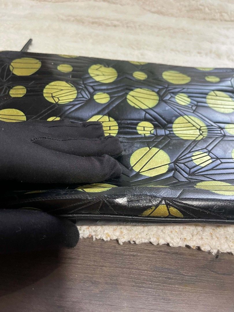 MCM Black and Gold Geometric Pattern Zip Clutch (Category: Clutches) located in Naawan. Submitted by twilly.apparel2 (Listing ID 1465825474, Image 2). Description: - issue may pressed mark and sign of use - authenticy NOT Guaranteed Eye-catching black clutch with bold gold polka dots and geometric linework - Secure zipper closure across the top - Dimensions: Roughly 14 inches long - Condition: Minor wear and peeling on the leather trim and gold f