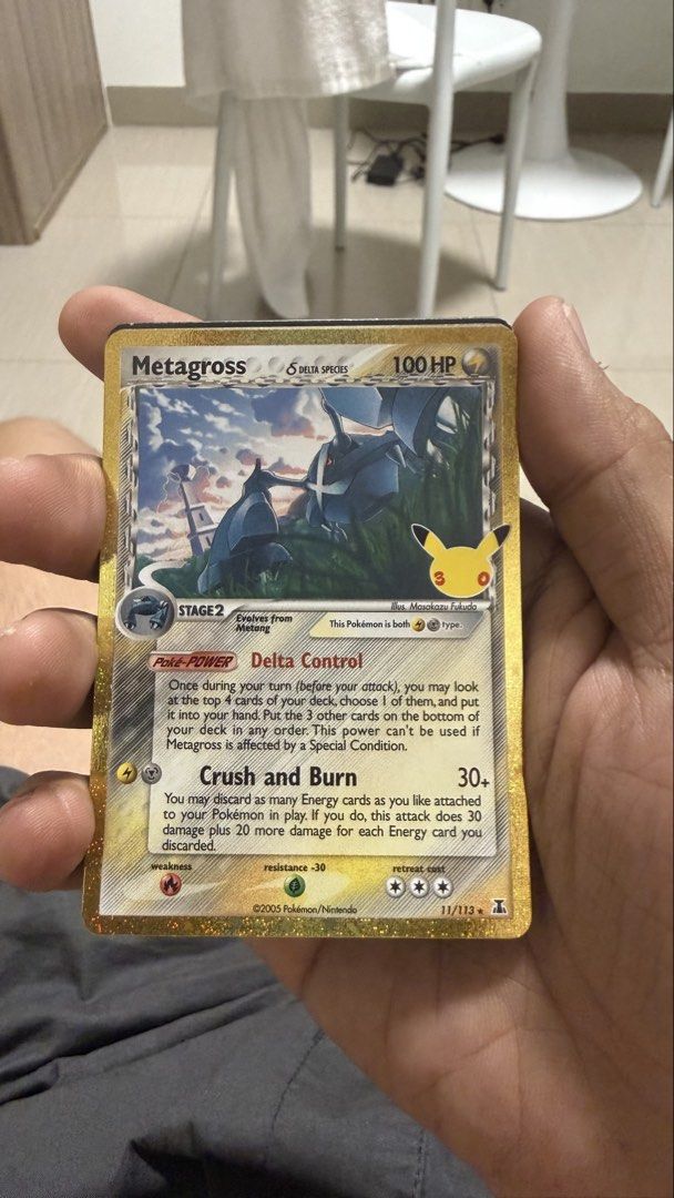 Metagross (Category: Raw Singles) located in Manila. Submitted by haroldgar13787 (Listing ID 1465776065, Image 1). Description: - Card Name/Set: Metagross Delta Species (11/113) - Edition: Gold Border Foil Edition (2005 Release) - Special Feature: Rare 25th-Anniversary Pikachu stamp on artwork - Stats: Stage 2, 100 HP, Psychic & Lightning Dual Type - Moves/Abilities: Delta Control Poké-Power & Crush and Burn Attack - Condition: Carefully stored, 