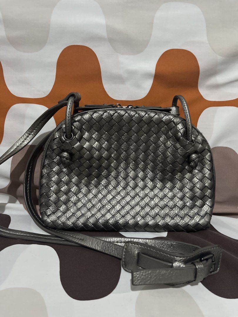 Metallic silver woven leather crossbody bag (Category: Cross-body Bags) located in Las Pinas. Submitted by erenrosc (Listing ID 1465893216, Image 1). Description: - Metallic silver leather shoulder bag with a stylish woven pattern - Secure double zipper top closure with leather pulls - Adjustable shoulder strap with trendy knotted side details - Dark fabric lining with a convenient slip pocket and zippered pocket - Compact and structured design, 