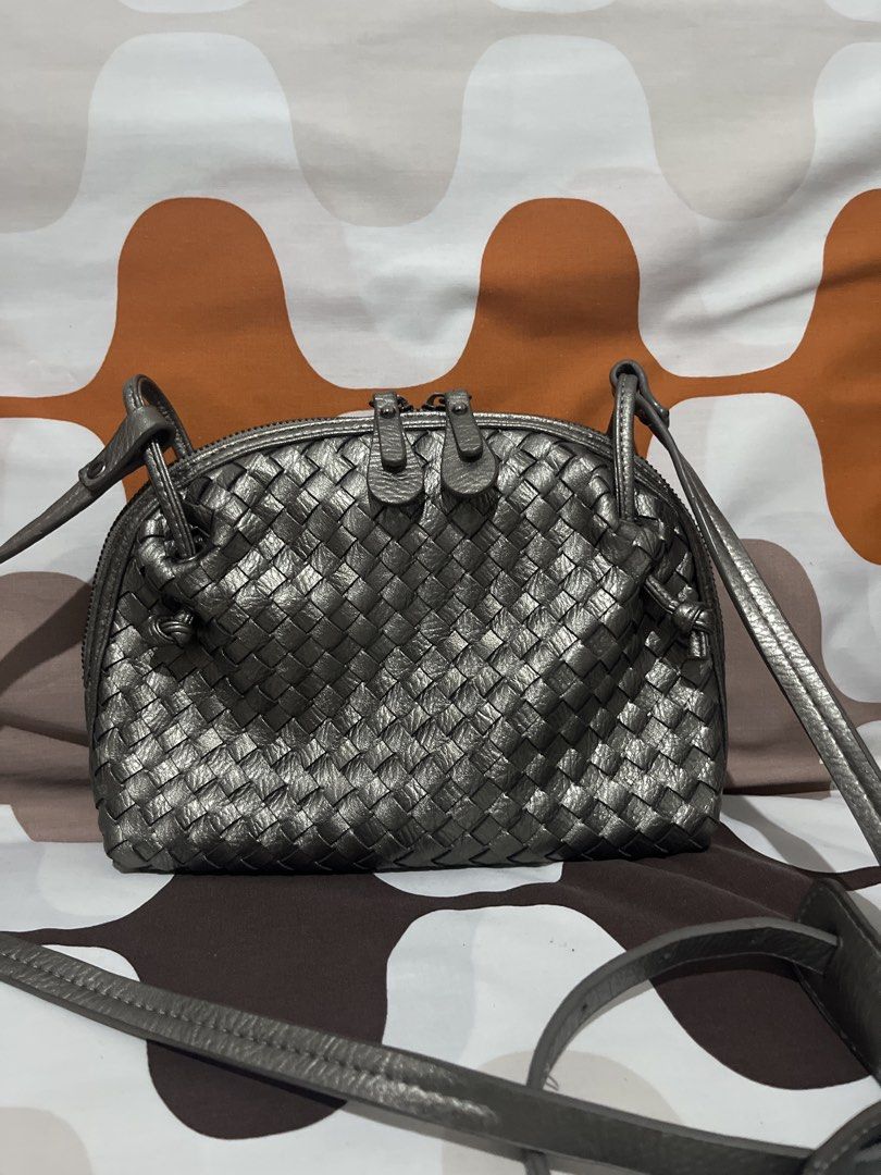Metallic silver woven leather crossbody bag (Category: Cross-body Bags) located in Las Pinas. Submitted by erenrosc (Listing ID 1465893216, Image 2). Description: - Metallic silver leather shoulder bag with a stylish woven pattern - Secure double zipper top closure with leather pulls - Adjustable shoulder strap with trendy knotted side details - Dark fabric lining with a convenient slip pocket and zippered pocket - Compact and structured design, 