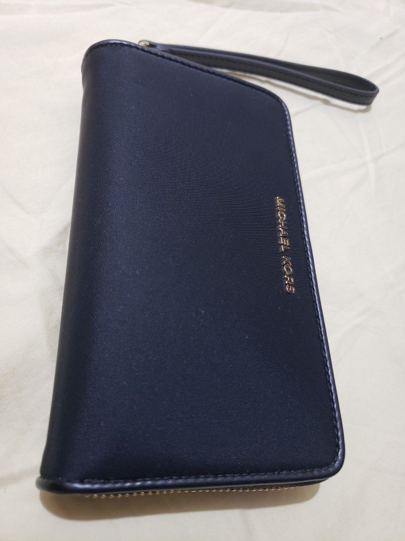 Michael Kors Black Zip Around Wallet With Wristlet Strap (Category: Wallets & Card holders) located in Navotas City. Submitted by miloklo (Listing ID 1465842667, Image 1). Description: Black Michael Kors zip around wallet. Gold tone hardware and matching wristlet strap. Interior holds multiple card slots, slip pockets, and a zippered coin compartment. Protective foam inserts and brand cards still inside. Clean black lining throughout. Zip closure