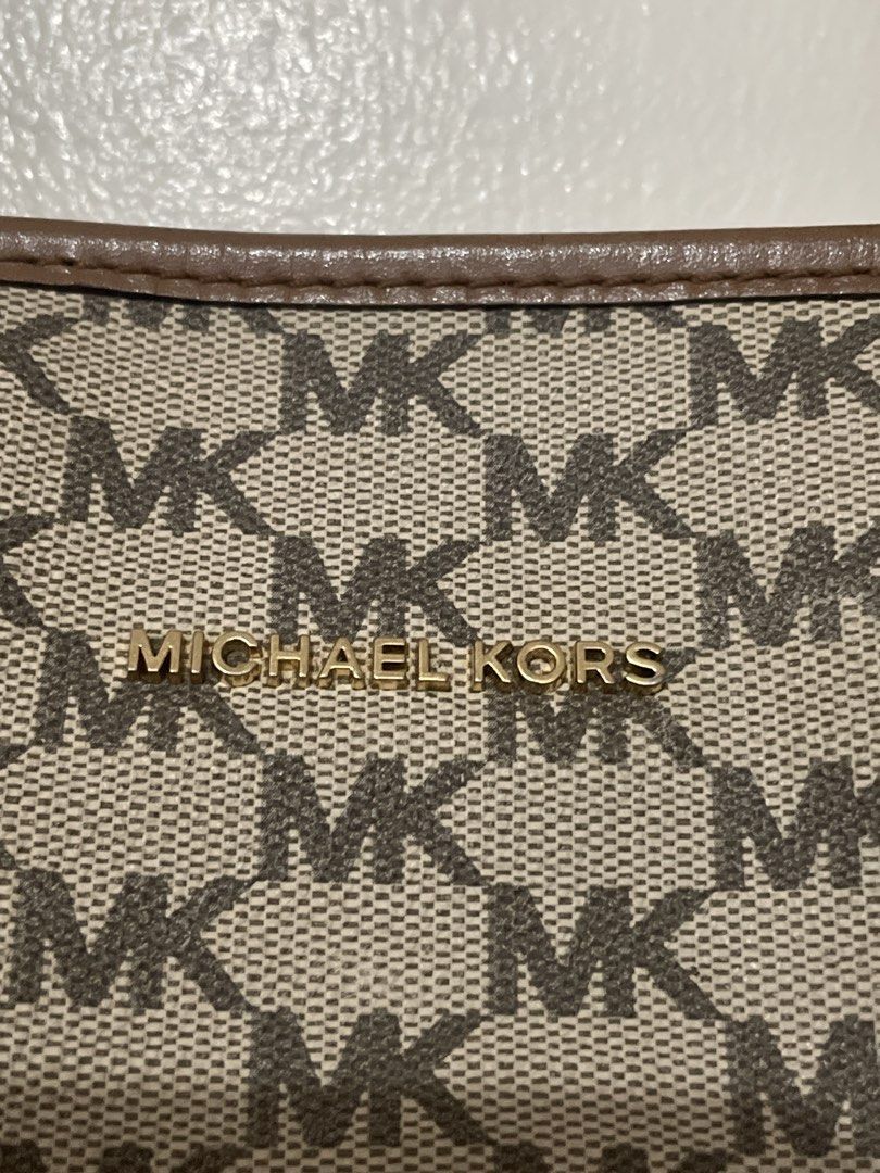 Michael Kors Brown MK Monogram Tote Bag (Category: Luxury Bags & Wallets) located in San Juan City. Submitted by redrosierose (Listing ID 1465950625, Image 2). Description: - Preloved Authentic Michael Kors tote bag in the iconic brown MK monogram pattern - Dual brown leather shoulder straps with clean stitching - Elegant gold-tone hardware and front logo lettering - Spacious interior, perfect for daily use and work essentials - Flaw: Noticeable 