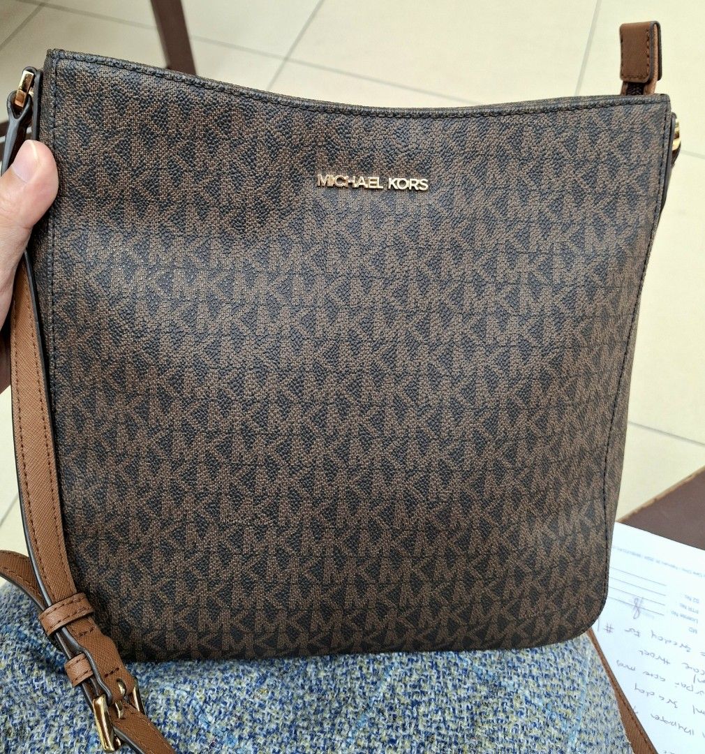 Michael Kors Brown Monogram Crossbody Bag (Category: Luxury Bags & Wallets) located in Manila. Submitted by selling_preloved_items1122 (Listing ID 1465783054, Image 1). Description: - Authentic Michael Kors crossbody bag - Classic brown MK monogram print with tan leather trim - Elegant gold-tone hardware - Secure top zipper closure - Convenient front slip pocket for phone or keys - Adjustable shoulder strap for custom fit - Clean interior lining 