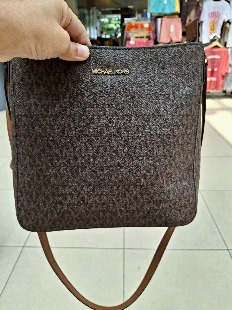 Michael Kors Brown Monogram Crossbody Bag (Category: Luxury Bags & Wallets) located in Manila. Submitted by selling_preloved_items1122 (Listing ID 1465783054, Image 2). Description: - Authentic Michael Kors crossbody bag - Classic brown MK monogram print with tan leather trim - Elegant gold-tone hardware - Secure top zipper closure - Convenient front slip pocket for phone or keys - Adjustable shoulder strap for custom fit - Clean interior lining 