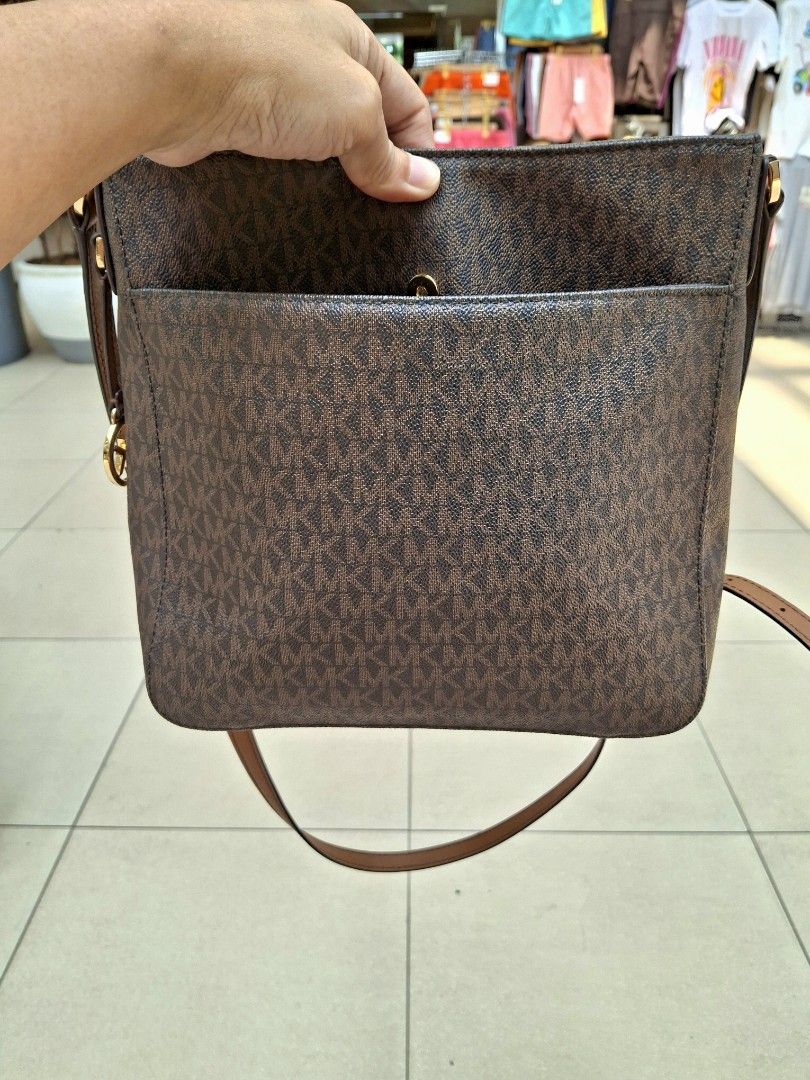 Michael Kors Brown Monogram Crossbody Bag (Category: Luxury Bags & Wallets) located in Manila. Submitted by selling_preloved_items1122 (Listing ID 1465783054, Image 3). Description: - Authentic Michael Kors crossbody bag - Classic brown MK monogram print with tan leather trim - Elegant gold-tone hardware - Secure top zipper closure - Convenient front slip pocket for phone or keys - Adjustable shoulder strap for custom fit - Clean interior lining 