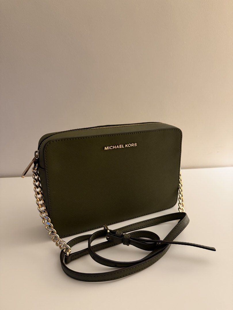 Michael Kors Green Crossbody Bag (Category: Cross-body Bags) located in Calamba. Submitted by wendyxdiane (Listing ID 1465825536, Image 1). Description: - Brand: Michael Kors - Color: Dark Olive Green - Material: Durable Saffiano leather - Hardware: Gold-tone with chain strap details - Strap: Includes adjustable leather shoulder strap - Closure: Zip top with engraved zipper pull - Condition: Clean exterior and corners, zero scratches on front met