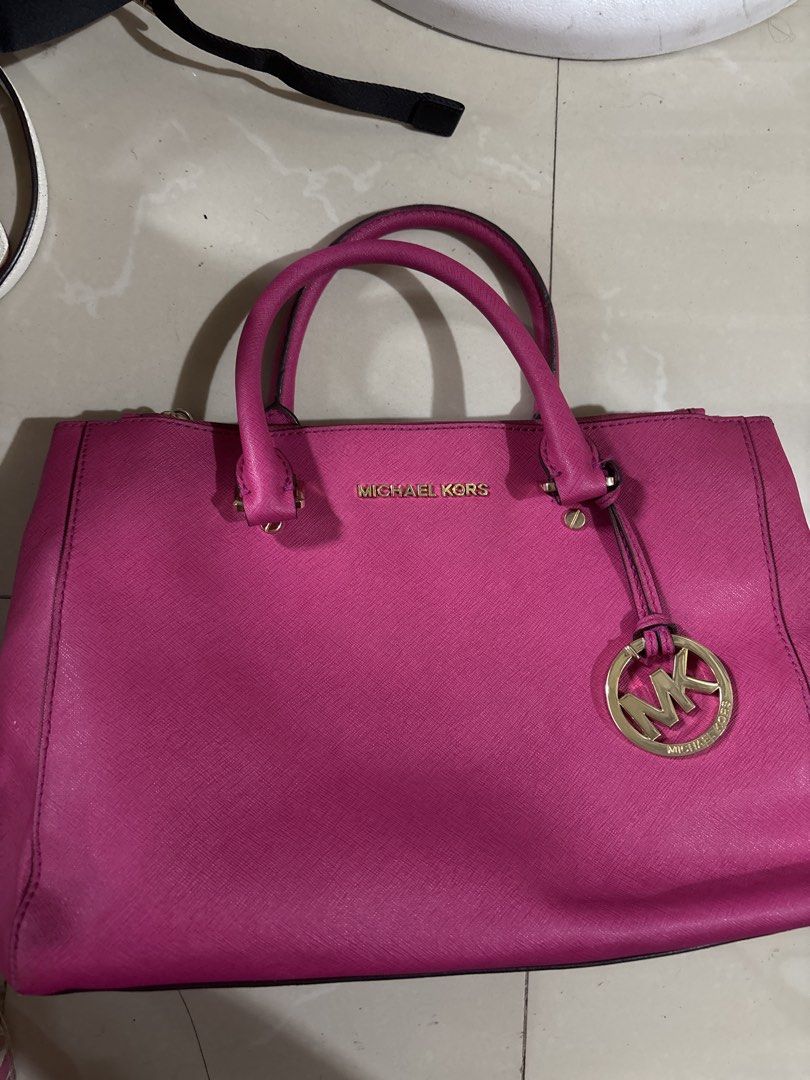 Michael Kors Pink Leather Tote Bag (Category: Luxury Bags & Wallets) located in Caloocan City. Submitted by sgnrkb (Listing ID 1465808986, Image 1). Description: - Authentic Michael Kors tote bag in a stunning bright pink shade - Crafted from durable Saffiano leather that holds its shape nicely - Elegant gold-tone hardware featuring the signature hanging MK logo charm - Convenient dual top handles for easy carrying - Interior zip compartments to 