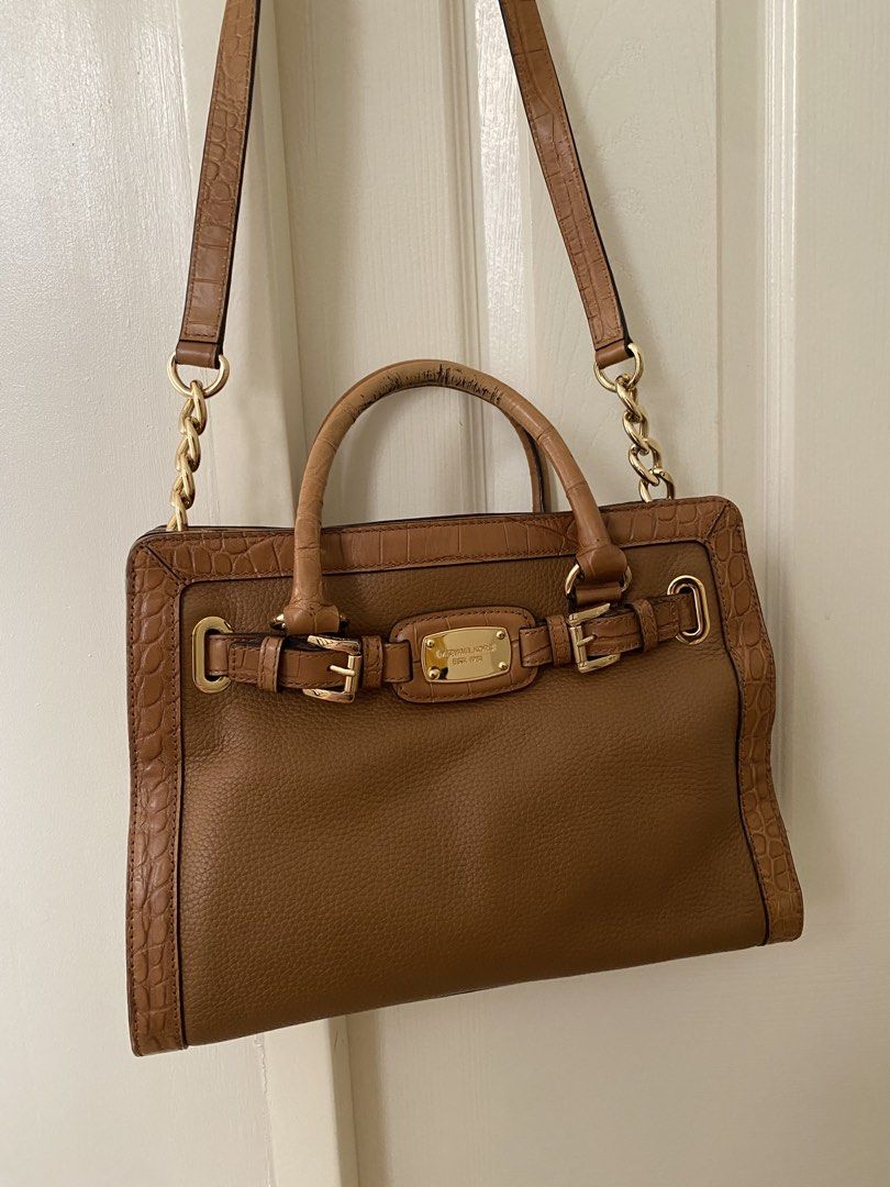 Michael Kors Hamilton Satchel (Category: Shoulder Bags) located in Las Pinas. Submitted by sherylandmargaux (Listing ID 1465846731, Image 2). Description: • Brand: MICHAEL Michael Kors • Model: Hamilton (East-West Satchel/Tote style) • Material: Brown pebbled leather body with croc-embossed trim and dual top handles • Hardware: Gold-tone accents, logo-engraved buckle/belt detail, and chain-link shoulder strap.