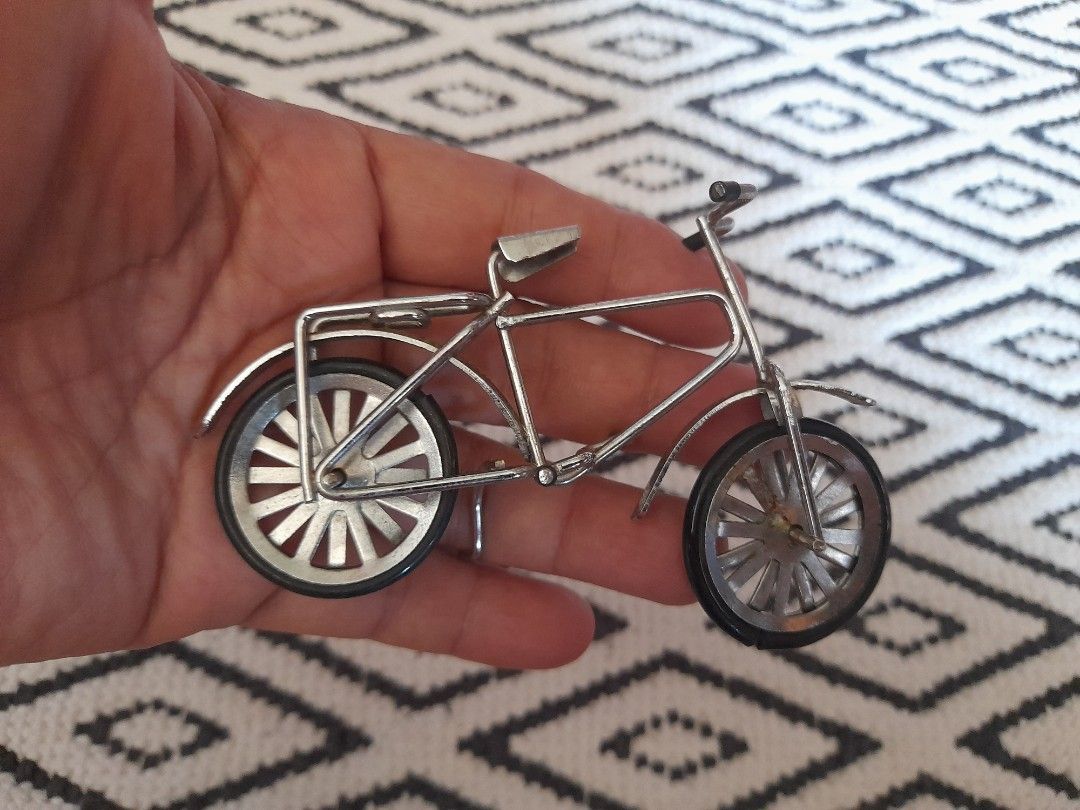 Miniature Silver Metal Bicycle Model Ornament (Category: Bicycles) located in Bocaue. Submitted by marajapansurplus (Listing ID 1465778517, Image 3). Description: - Detailed miniature silver-colored bicycle model made from metal wire - Accented with realistic black rubber grips on handlebars and pedals - Stands firmly on its own, making it an ideal decor piece for desks or shelves - Compact size perfect for collectors and bike enthusiasts.