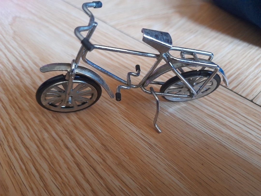 Miniature Silver Metal Bicycle Model Ornament (Category: Bicycles) located in Bocaue. Submitted by marajapansurplus (Listing ID 1465778517, Image 2). Description: - Detailed miniature silver-colored bicycle model made from metal wire - Accented with realistic black rubber grips on handlebars and pedals - Stands firmly on its own, making it an ideal decor piece for desks or shelves - Compact size perfect for collectors and bike enthusiasts.