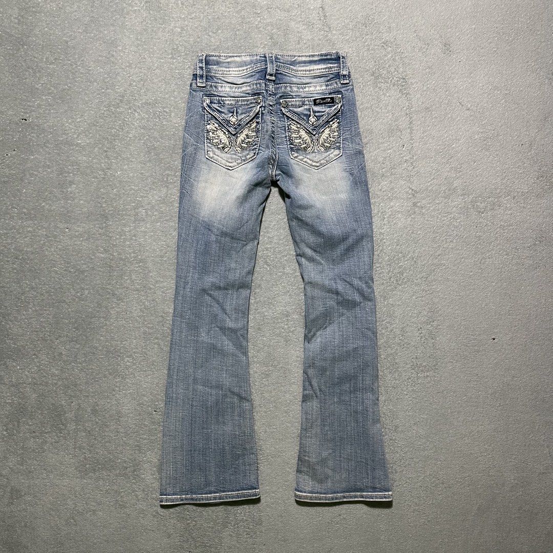 Miss Me Bootcut Jeans Size 8 (Category: Jeans) located in Villaverde. Submitted by bakatzy_secondhand_garments (Listing ID 1465886458, Image 1). Description: - Brand/Model: Miss Me Girls Bootcut Jeans (Style: K3080BG, Color: L186) - Size: 8 (Tag at waist) - Wash: Medium wash with stylish light fading on thighs and knees - Details: Eye-catching rhinestone wing embellished button-flap back pockets and contrast white stitching - Material: 92% cotton