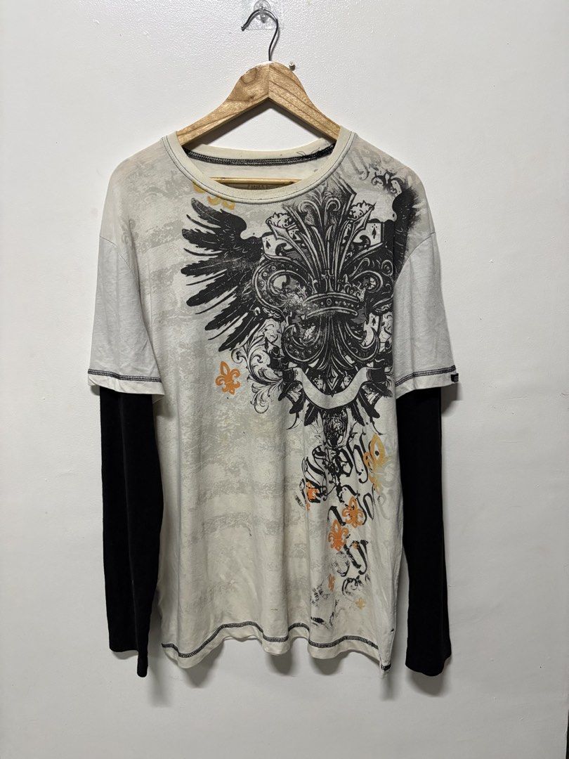 MMA Elite Long Sleeve Layered Graphic Tee (Category: Tshirts & Polo Shirts ) located in Manila. Submitted by swag_shop00 (Listing ID 1465810830, Image 1). Description: - Brand: MMA Elite - Style: Long sleeve layered t-shirt (white with contrast black sleeves) - Design: Large winged fleur-de-lis graphic print on front and back - Size: XL - Fit: Regular fit, crew neck - Material: Cotton and polyester blend.