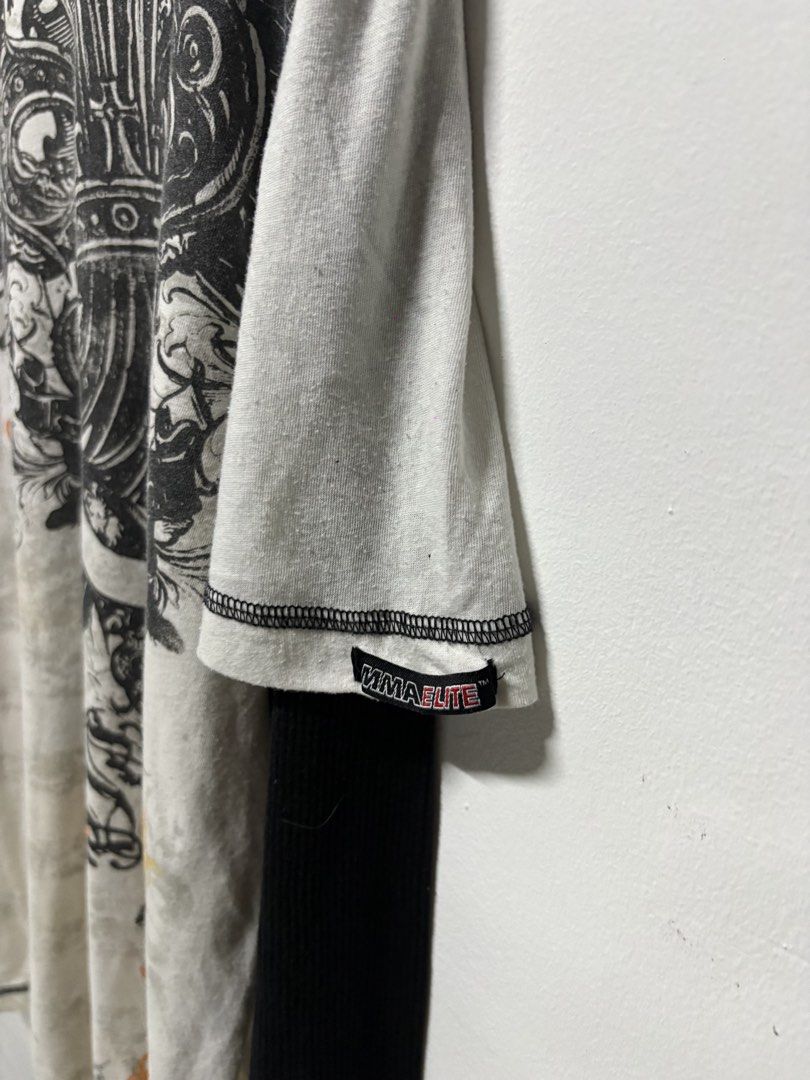 MMA Elite Long Sleeve Layered Graphic Tee (Category: Tshirts & Polo Shirts ) located in Manila. Submitted by swag_shop00 (Listing ID 1465810830, Image 3). Description: - Brand: MMA Elite - Style: Long sleeve layered t-shirt (white with contrast black sleeves) - Design: Large winged fleur-de-lis graphic print on front and back - Size: XL - Fit: Regular fit, crew neck - Material: Cotton and polyester blend.