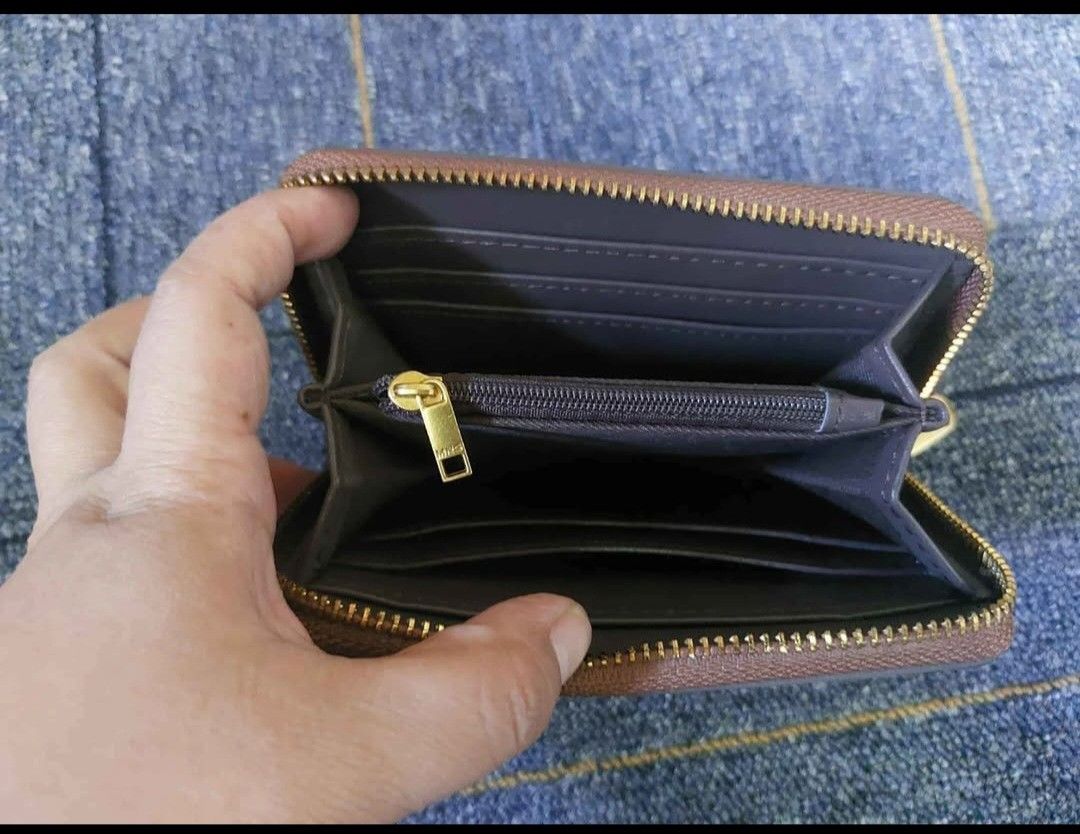 MNG patterned zip-around wallet (Category: Wallets & Card holders) located in Manila. Submitted by fiercebird_38dcf5 (Listing ID 1465882262, Image 3). Description: - Brand: MNG - Design: Brown and cream geometric pattern with gold-tone hardware and metal brand plaque - Closure: Secure zip-around closure - Interior: Multiple card slots, slip pockets, dark grey lining, and a central zippered coin compartment - Size: Compact, fits easily into most b