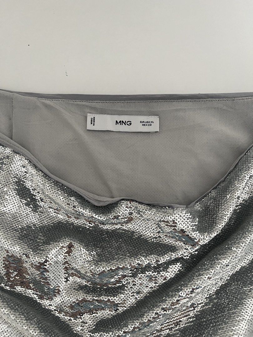 Mango Silver Sequin Mini Skirt (Category: Skirts) located in Quezon City. Submitted by cooperminie (Listing ID 1465816099, Image 3). Description: - Size: XL (Waist: approx. 18.5" across, Length: approx. 18", fabric slightly stretchy) - Color/Design: All-over shiny silver sequins with a comfortable grey lining and waistband - Closure: Easy-to-use back zipper - Perfect for: Parties, night outs, concerts, and events - Condition: Great statement piec