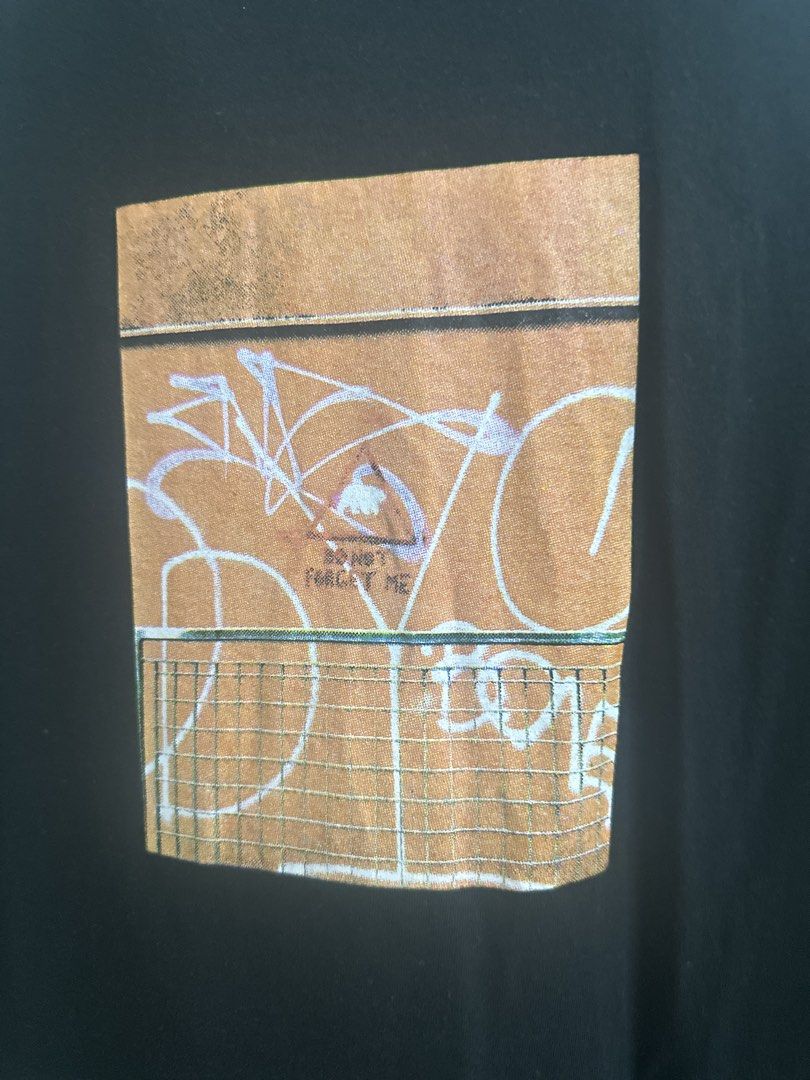 MN+LA Black Graphic T-Shirt (Category: Tshirts & Polo Shirts ) located in Manila. Submitted by royal_vintage_thriftshop (Listing ID 1465810947, Image 3). Description: Black t-shirt from MN+LA. Heavyweight cotton fabric with a structured ribbed collar. Graphic print on the chest featuring a fence and abstract graffiti art with text detail. Size large, relaxed fit. Width measures 25 inches, length is 29 inches based on the official size chart. Mini