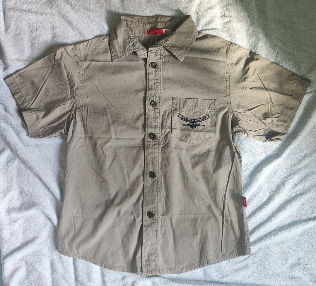Mossimo Kids Button-Up Shirt Size 8 Beige (Category: Babies & Kids Fashion) located in Manila. Submitted by rarelion_c637f7 (Listing ID 1465853121, Image 1). Description: Mossmo kids button-up shirt in beige. Short sleeves, standard collar, front button closure. Left chest pocket features embroidered text detailing. Small red brand tag on the lower left side seam. Clean look overall, great for everyday wear or casual outings..