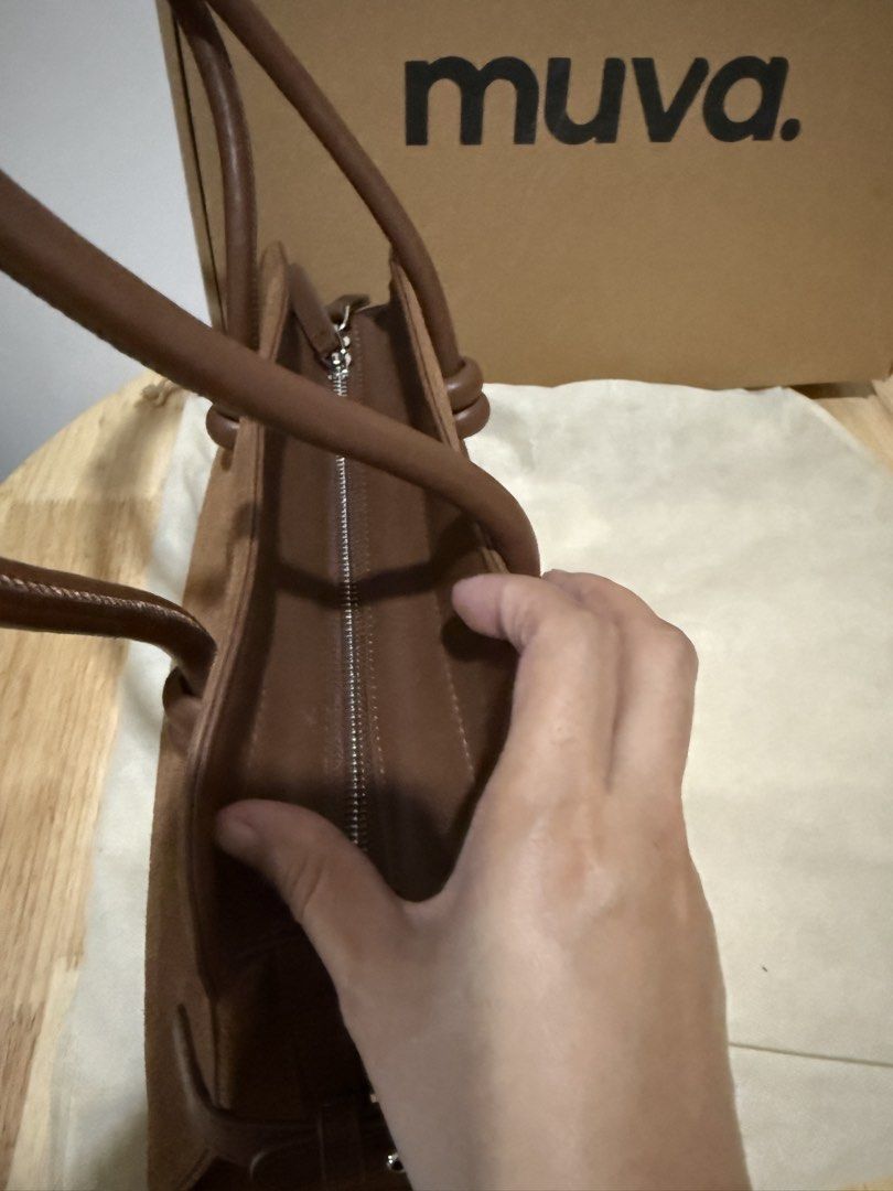 Muva Suede Shoulder Bag Brown (Category: Shoulder Bags) located in Mandaluyong City. Submitted by decmnl (Listing ID 1465856217, Image 3). Description: - Brand: Muva - Material: Premium brown suede (genuine) - Style: Structured shoulder bag with side strap details: still avail in website and official online store - Handles: Double top handles with chic knotted accents - Closure: Secure zip top closure - Inclusions: Generic dust bag and branded bo