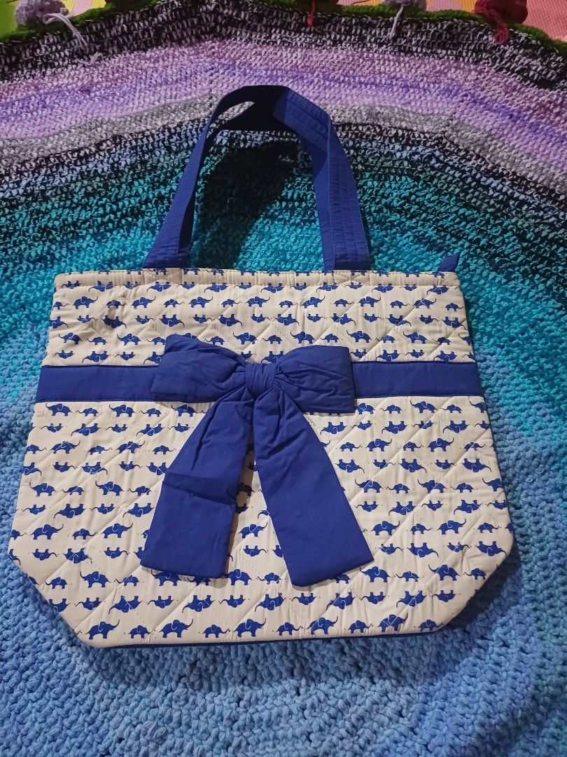 Naraya ' Quilted Tote Bag Blue Elephant Pattern with Bow (Category: Tote Bags) located in San Pedro. Submitted by purpledream0316 (Listing ID 1465893851, Image 1). Description: - Design: Adorable all-over blue elephant pattern with a solid blue ribbon bow on the front - Material: Soft and comfortable quilted fabric - Size: Approx. 14 inches wide x 16 inches tall (spacious enough for daily essentials) - Straps: Two sturdy blue shoulder straps for 