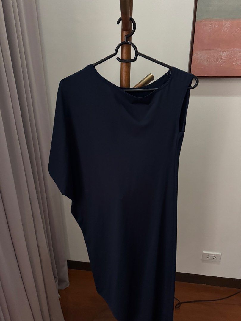 Navy Blue Asymmetric Midi Dress (Category: Dresses) located in Pasig City. Submitted by kutleyn (Listing ID 1465760112, Image 2). Description: - Color: Solid black - Style: Asymmetric midi dress with minimalist design - Features: One draped batwing sleeve, one sleeveless side, boat neckline - Fit: Flowy and comfortable - Material: Soft, stretchy fabric that drapes nicely - Occasion: Ideal for dinners and evening events; easy to dress up with heel