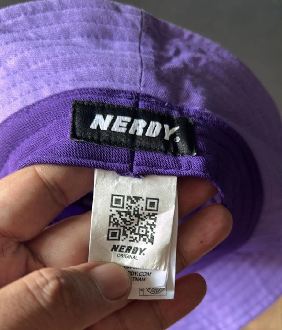 Nerdy Purple Bucket Hat (Category: Caps & Hats) located in General Santos City (Dadiangas). Submitted by moana_thrifts (Listing ID 1465811508, Image 3). Description: - Brand: Nerdy - Color: Bright purple - Material: Sturdy cotton twill - Design: Embroidered signature 'N' logo on front, full brand name on back in white stitching - Fit: Classic unstructured fit - Style: Casual everyday streetwear.