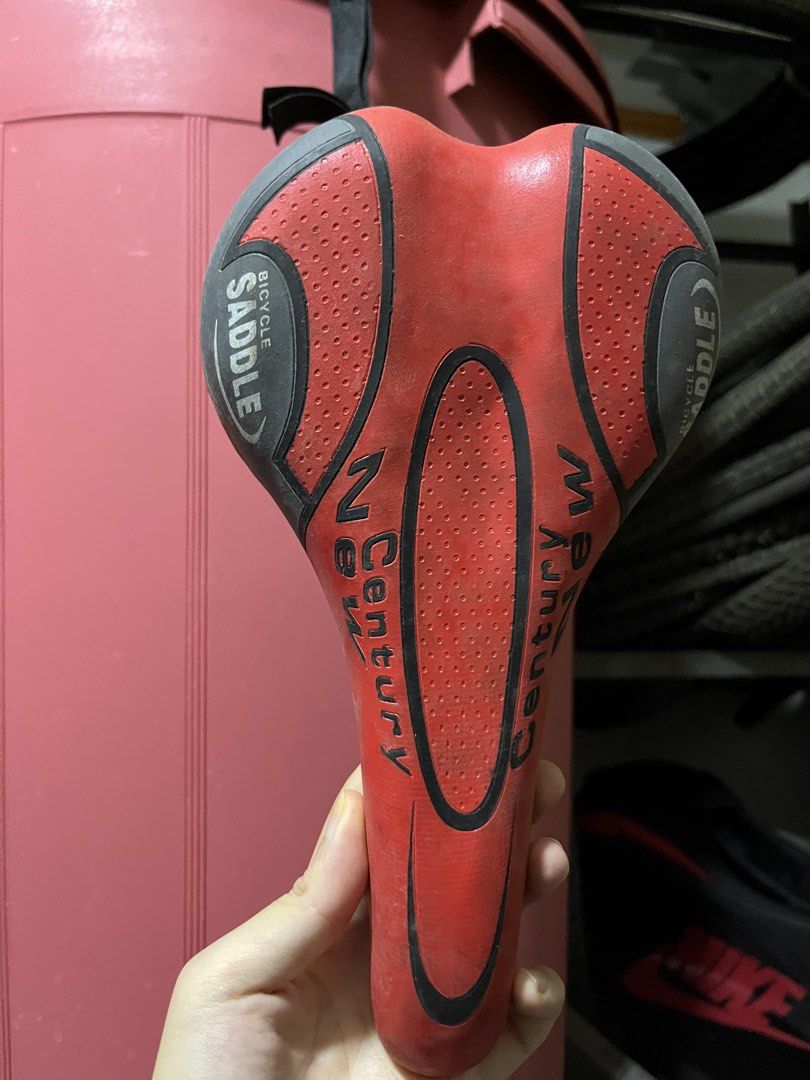 New Century Bicycle Saddle Red Black (Category: Bicycles) located in Santa Rosa. Submitted by weltfish (Listing ID 1465926766, Image 1). Description: Please just message for any questions :) - Color: Red and black - Comfort: Cushioned surface with textured grip patterns and ventilation cutout - Compatibility: Fits standard seatposts - Hardware: Mounting clamp attached underneath with dual rails - Condition: Bottom stapled finish with some wear on