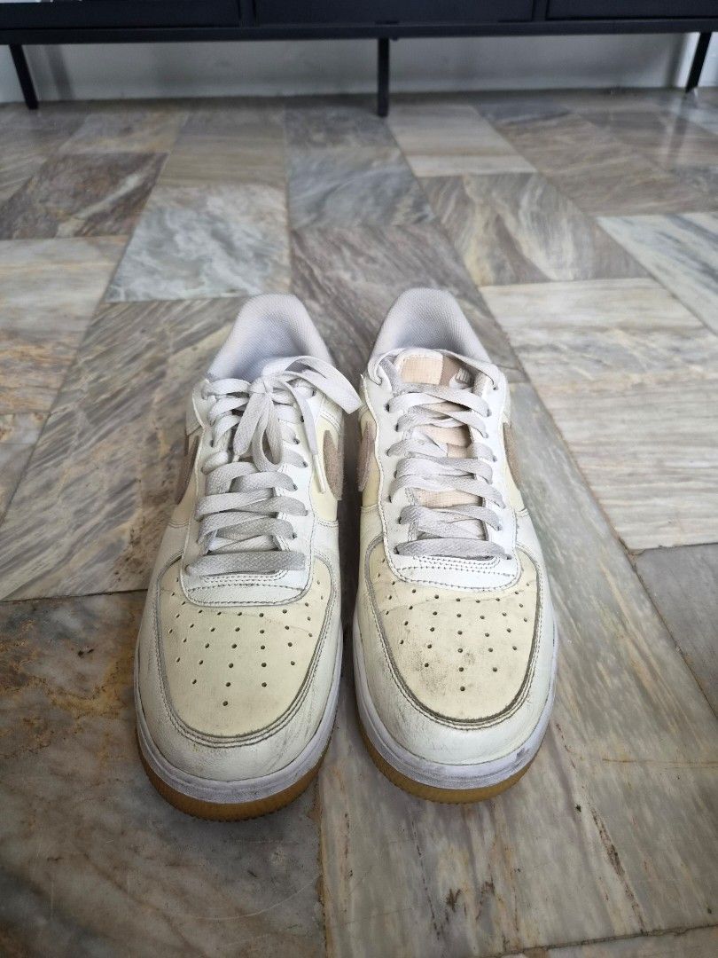 Nike Air Force 1 Low (Category: Sneakers) located in Quezon City. Submitted by mimi0024 (Listing ID 1465802217, Image 1). Description: - Brand/Model: Nike low-top sneakers - Colorway: White leather with beige suede accents and gum outsoles - Size: US 9.5 / UK 8.5 / EUR 43 / CM 27.5 - Features: Standard lace-up closure and embroidered Nike Air branding on heel tabs - Condition: General wear on uppers and midsoles with visible creasing.