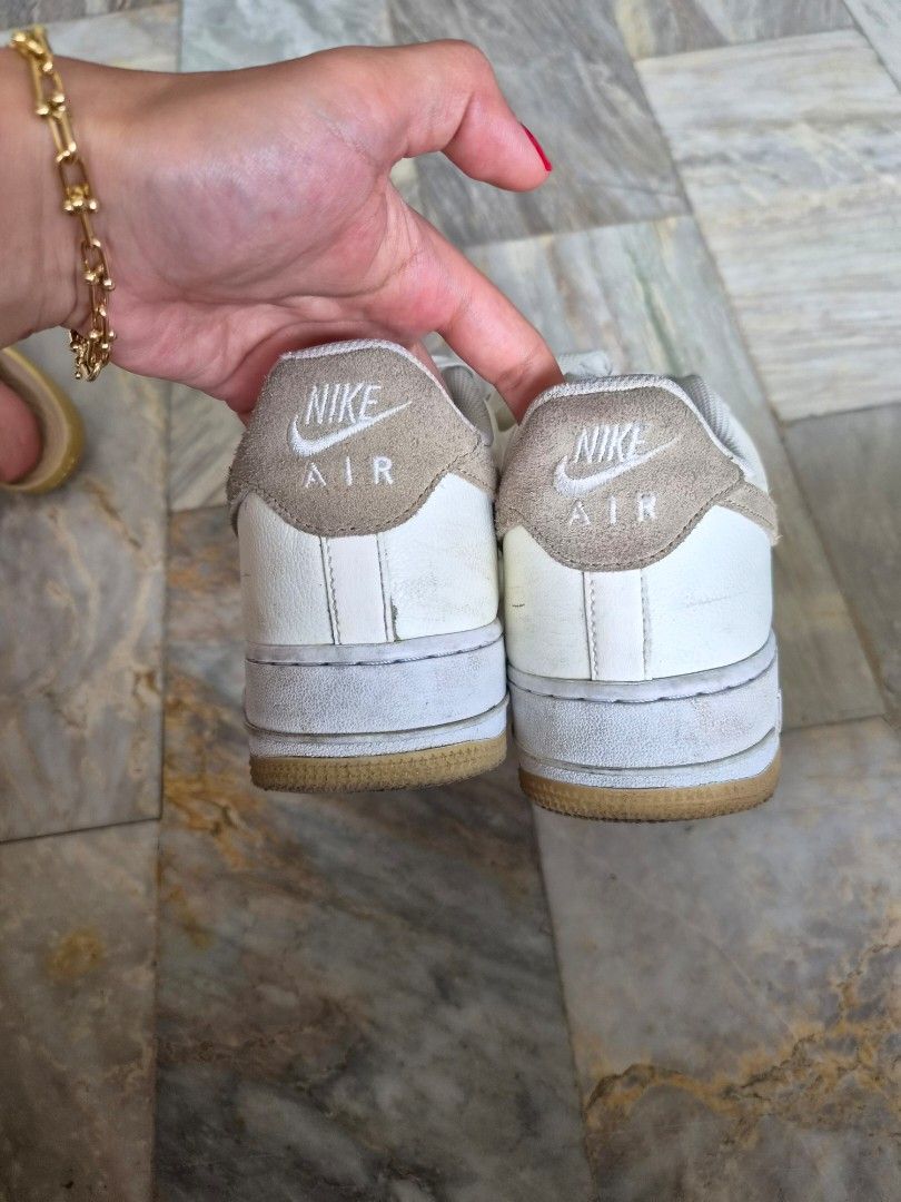 Nike Air Force 1 Low (Category: Sneakers) located in Quezon City. Submitted by mimi0024 (Listing ID 1465802217, Image 2). Description: - Brand/Model: Nike low-top sneakers - Colorway: White leather with beige suede accents and gum outsoles - Size: US 9.5 / UK 8.5 / EUR 43 / CM 27.5 - Features: Standard lace-up closure and embroidered Nike Air branding on heel tabs - Condition: General wear on uppers and midsoles with visible creasing.