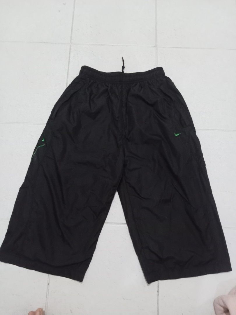 Nike Black Athletic Shorts (Category: Shorts) located in Manila. Submitted by kitkathrift (Listing ID 1465869374, Image 1). Description: - Brand: Nike - Style: Athletic shorts / knee-length capri - Color: Black with green Nike swoosh and side text graphic - Waistband: Elastic with adjustable drawstring - Material: Lightweight nylon - Condition: Good, ready to wear - Features: Size tag intact inside, ideal for workouts or casual days.