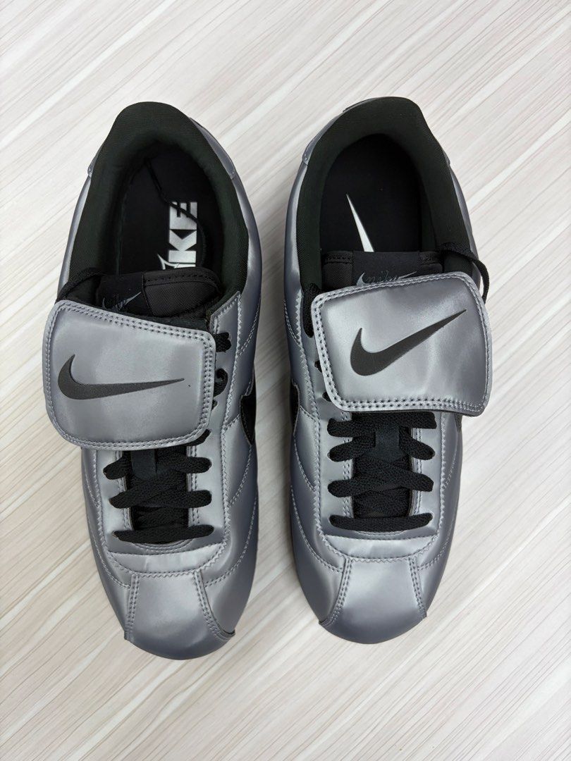 Nike Cortez SE Metallic Cool Grey / Black 72 (Category: Sneakers) located in Makati City. Submitted by sonnybau (Listing ID 1465839507, Image 3). Description: - Colorway: Metallic silver upper with black swoosh, laces, and outsole - Design: Distinct fold-over lace cover with embossed Nike branding and number 72 on the left heel panel - Sole: Gum zigzag tread for added grip and a striking look - Condition: Clean interior lining with original paper