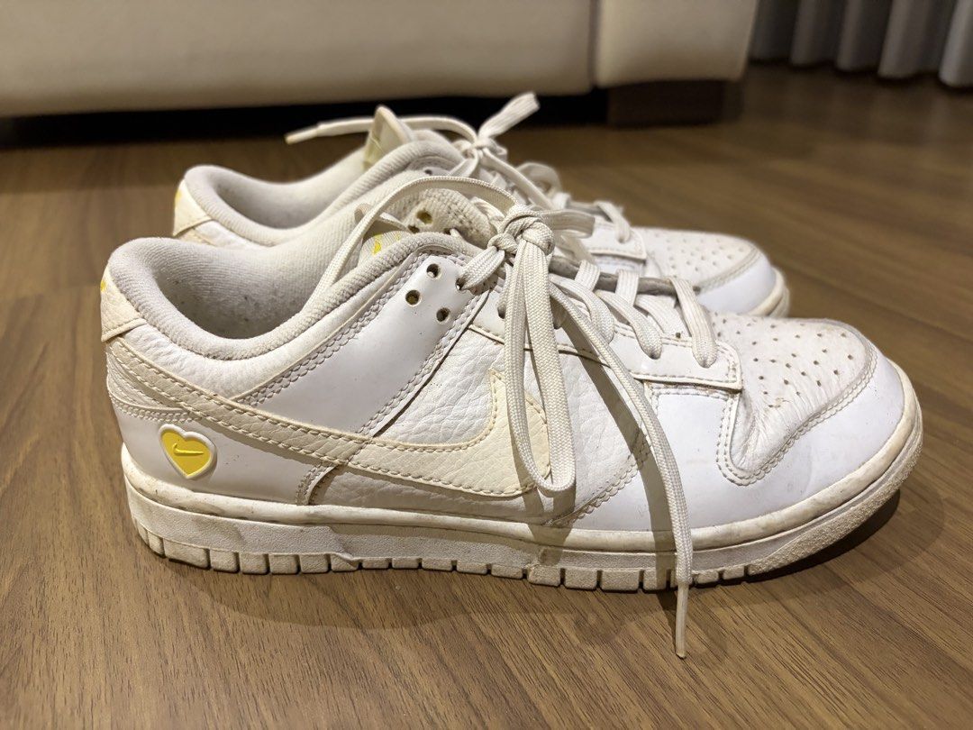 Nike Dunk Low White Yellow Heart (Category: Sneakers) located in Quezon City. Submitted by krishagee (Listing ID 1465911287, Image 1). Description: - Brand/Model: Nike low-top sneakers - Color: White leather with yellow swoosh - Special Detail: Yellow heart emblem near the heel - Features: Standard lace-up closure and perforated toe box - Condition: Normal signs of wear, faded inner sole branding, and dirt marks on the rubber sole.