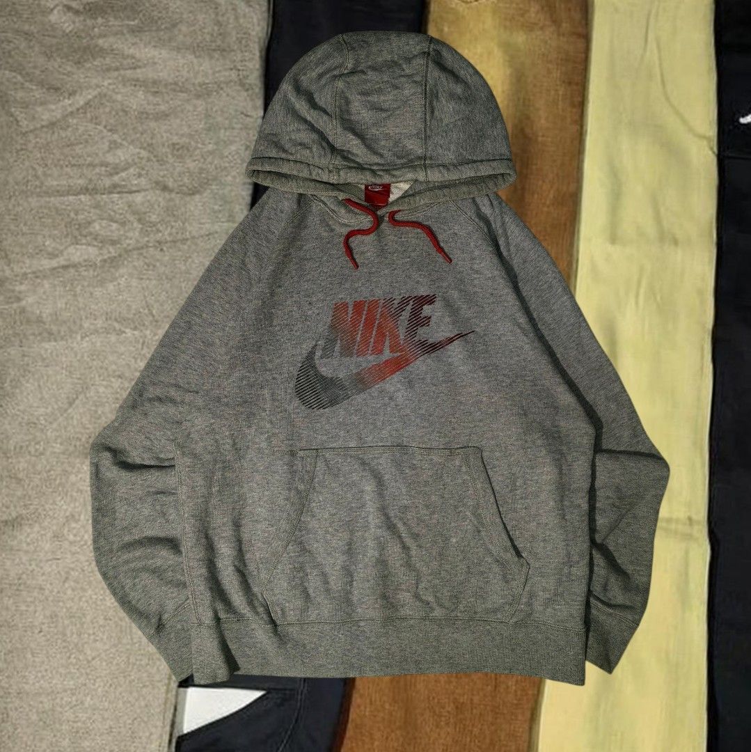 Nike Grey Gradient Swoosh Logo Pullover Hoodie Size L (Category: Hoodies) located in Mabitac. Submitted by kitothrifty (Listing ID 1465862729, Image 1). Description: - Size: Large - Color: Grey with red and black gradient logo - Material: 100% cotton body for comfort - Features: Red drawstrings with branded metal aglets, front kangaroo pocket, ribbed cuffs and hem - Origin: Made in China - Style: Classic streetwear piece.