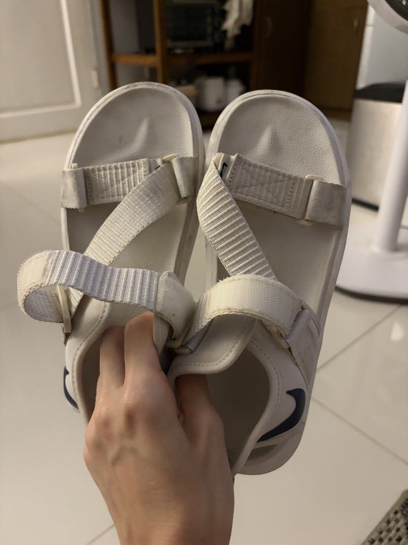 Nike White Sandals (Category: Flats & Sandals) located in Pasig City. Submitted by sums.chivs (Listing ID 1465912342, Image 1). Description: - Color: White with navy blue swoosh logo - Style: Open toe, thick platform sole for extra comfort - Closure: Adjustable velcro straps for easy on and off - Ideal for: Casual walking, daily wear, or beach trips RFS: Too small.