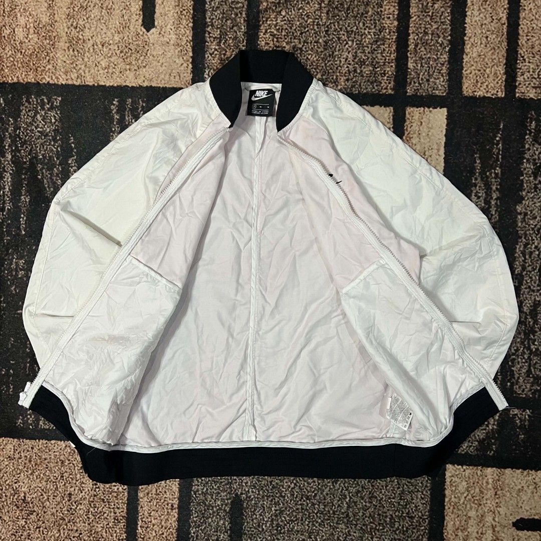 Nike White/pink Bomber Jacket Zip Up (Category: Coats, Jackets and Outerwear) located in Cebu City. Submitted by royalwolf-2a85 (Listing ID 1465920125, Image 3). Description: - Brand: Nike - Style: Zip-up bomber jacket - Color: White and black - Size: Medium - dimes 20x26 - excellent condition - have yellow stain - but need wash/washable - Features: Ribbed black collar, cuffs, and hem; front zip pockets with white zipper pull; embroidered Nike lo